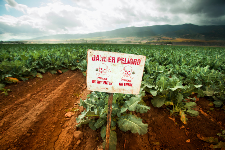 Pesticide warning sign on fertile farm land
