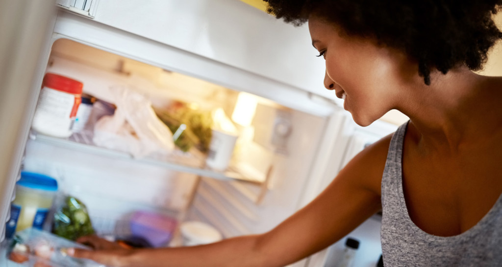 Woman grabbing food in fridge