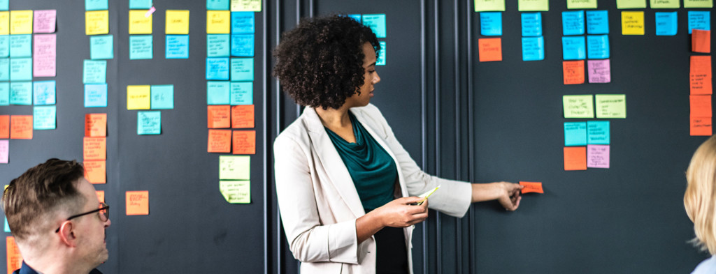 Woman arranging post-its on wall