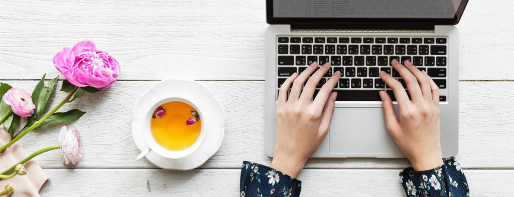 Woman working on laptop with tea