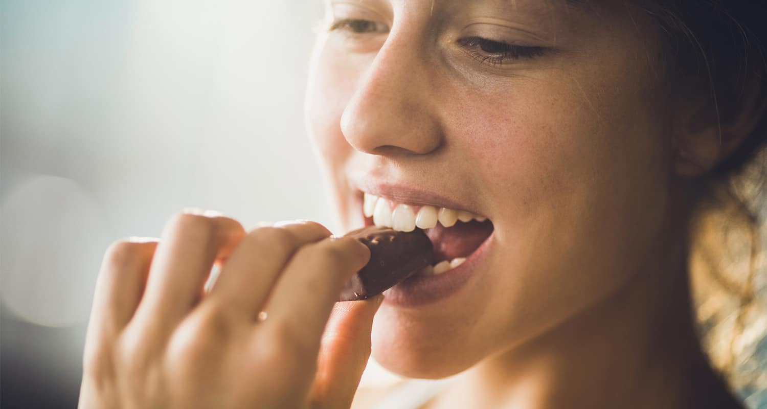 Woman eating chocolate for gut health