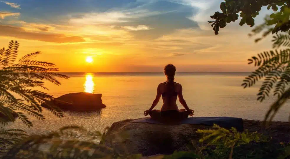 yoga-practicing-at-sunset-meditation-559454563.webp
