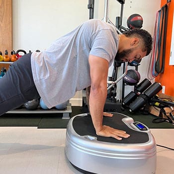 Man doing a pushup on a Power Plate for Holiday Promotion ad