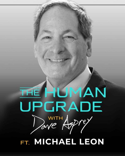 Black and white photo of a smiling man in a suit. Overlaid text reads: The Human Upgrade with Dave Asprey ft. Michael Leon..