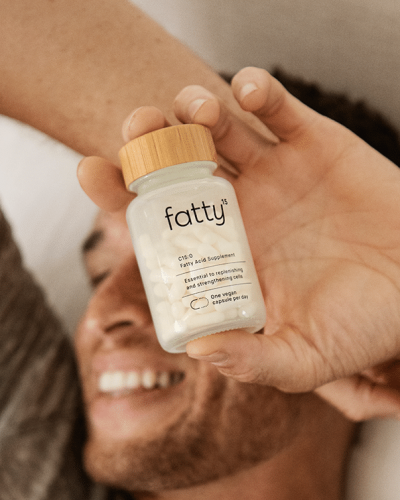 Man holding a bottle of Fatty™ supplements