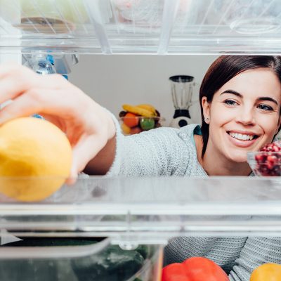 Woman grabbing food in fridge